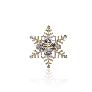 Detailed view of a gold snowflake brooch with sparkling cubic zirconia stones