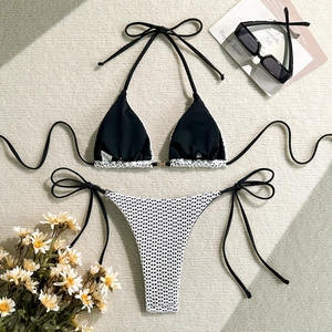 Detail of knit hollow-out bikini with black crochet top and white lace weave bottom
