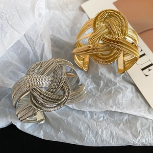 Detail of multi-layered spiral metal chain braided cuff bracelet in gold and silver