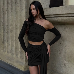 Detail of black one-shoulder long sleeve top and ruched mini skirt set for women