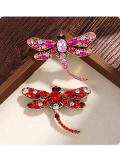 Macro view of vintage dragonfly brooches with vibrant pink and red sparkling rhinestones