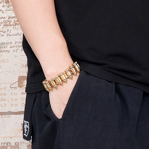 Close-up of men's gold bullet-style titanium steel bracelet worn on a wrist in a pocket