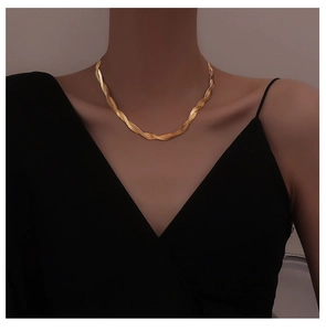 Detailed close-up of a twisted gold snake chain necklace worn on a female model neck