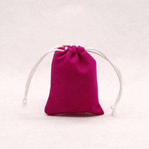 Macro detail of small rose red velvet drawstring jewelry pouch with white cord closure