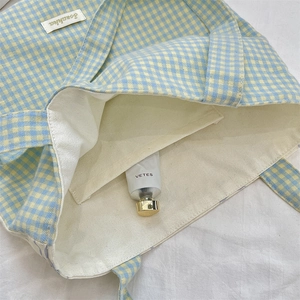 Close-up of internal pocket and beige canvas lining of the plaid tote handbag