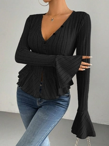 Detail of black vertical striped knit top featuring V-neck and ruffle flare cuffs