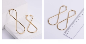 Detail of 7cm large figure-eight gold hoop earrings in 18k vacuum plated stainless steel