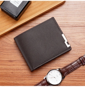 Brown lychee grain leather wallet with silver metal edge detail on wooden desk