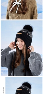 Detail of black winter knit trapper hat featuring faux fur pom and leather logo patch