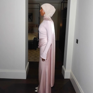 Detail view of pink satin Muslim evening gown with ruffled waist and flared sleeve design