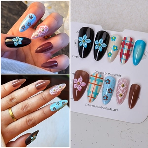 Detail of almond-shaped Christmas press-on nails with 3D floral and plaid hand-painted patterns
