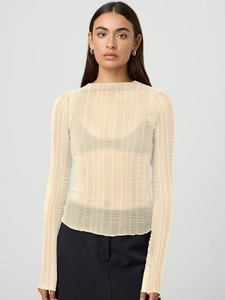 Detail of sheer apricot knit fabric with vertical ribbed texture on long sleeve top