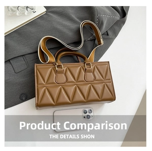 Brown quilted PU leather handbag with wide shoulder strap next to phone for size reference