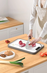 Detail of durable white PP cutting board with non-slip gray edges and hanging handle hole