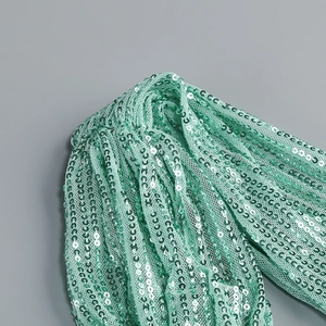Close-up of mint green sequin fabric on mesh base for elegant evening dress