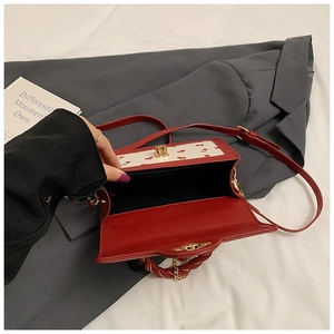 Interior view of cherry print crossbody bag with gold twist lock and red handle