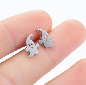Macro shot of silver ghost stud earrings held by hand showing small festive size