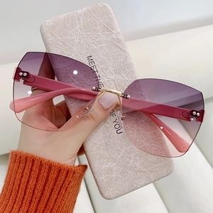 Close-up of rimless gradient purple sunglasses with rose gold metal bridge and marble case