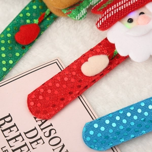 Detail of sequined Christmas slap bracelets with glowing Santa plush and festive patterns