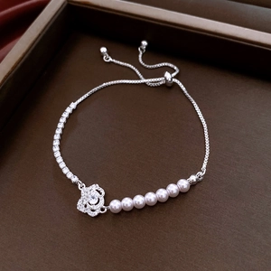 Detailed macro of French style pearl bracelet with zircon camellia flower and slider clasp