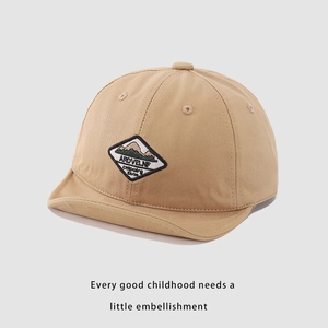 Close-up of khaki cotton baby baseball cap featuring a mountain peak embroidery patch