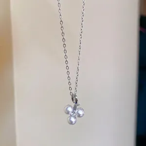 Minimalist stainless steel necklace featuring a three-pearl clover pendant and zircon accent