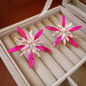Luxury pink and clear crystal snowflake star stud earrings in a jewelry box display