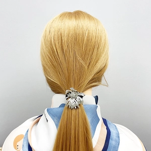Detailed view of silver flower alloy hair ring tied on a blonde ponytail for styling