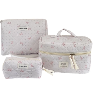 Pink quilted makeup bag set with white polka dots and bow pattern on a white background