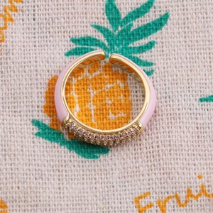 Detailed shot of pink enamel open ring with sparkling pavé zircons and gold plating