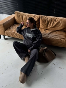 Detail of grey half-zip sweatshirt with white letter embroidery and wide-leg joggers