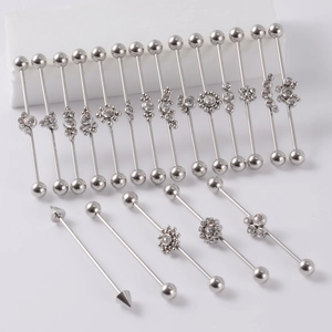 Close-up of industrial barbell body jewelry set in silver stainless steel with rhinestones