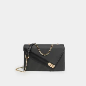 Detail of cross-grain leather texture and golden chain strap on a black envelope bag