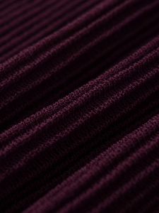 Vue macro du tissu en maille côtelée violet foncé avec détails plissés élégants