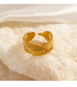 Macro shot of gold leaf feather ring showing detailed texture on mineral stone base