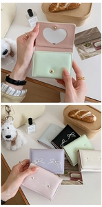 Detail of compact bow wallet with pearl decor and heart-shaped transparent window
