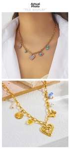 Detail of layered gold chains with evil eye, heart charms and sunflower pendants