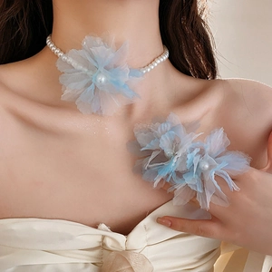 Close-up of floral mesh pearl necklace and matching corsage with blue gradient petals