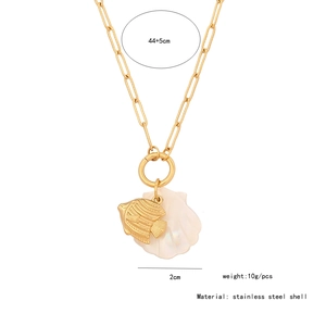 Detail of a paperclip chain necklace featuring a gold fish and an iridescent shell pendant