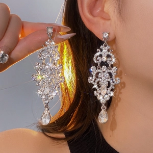 Gros plan de boucles d'oreilles à pampilles argentées avec strass brillants et gouttes