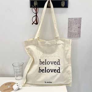 Detail of Beloved gradient embroidery on a cream canvas tote bag with minimalist styling