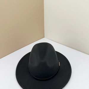 Detail of black wool fedora hat featuring a leather band and gold metal buckle accent