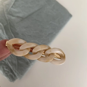 Detail shot of vintage cream marble chain hair clip with golden metal base