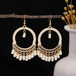 Bohemian geometric round hoop earrings with white handmade beads and tassel detail