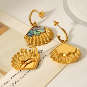 Macro detail of golden seashell jewelry set with abalone inlay and open ring design