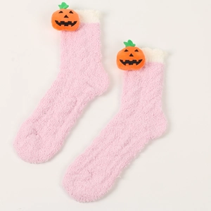 Detail von rosa Korallenvlies-Thermosocken mit einer süßen 3D-Kürbispuppen-Dekoration