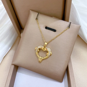 Detailed close-up of a gold dolphin heart necklace featuring brilliant pavé crystals