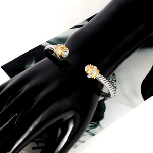 Close-up of a two-tone twisted cable bangle with sparkling zircon stone settings