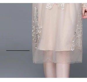 Détails de la broderie florale complexe sur l'ourlet de la robe en tulle