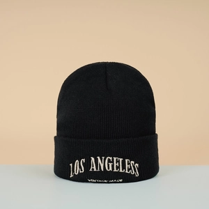 Détail de la broderie blanche Los Angeles et de la maille sur un bonnet noir d'hiver